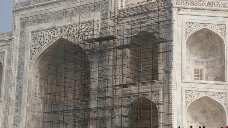 Des touristes visitent le Taj Mahal et passent devant des échafaudages installés pour rénover le monument, à Agra en Inde, le 3 janvier 2018 [DOMINIQUE FAGET / AFP]
