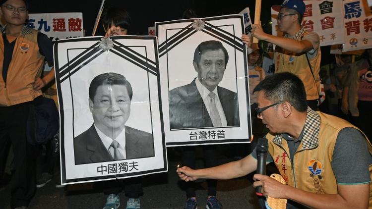 Un militant pour l'indépendance de Taïwan s'apprête à brûler des photos des dirigeants chinois et taïwanais, le 7 novembre 2015 à Taipei [STR / AFP]