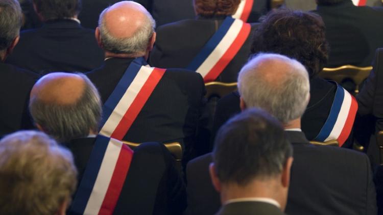 Des maires ayant revêtu leur écharpe tricolore écoutent Nicolas Sarkozy (hors champ), alors président de la République, le 20 novembre 2009 u palais de l'Elysée à Paris [Charles Platiau / POOL/AFP/Archives]