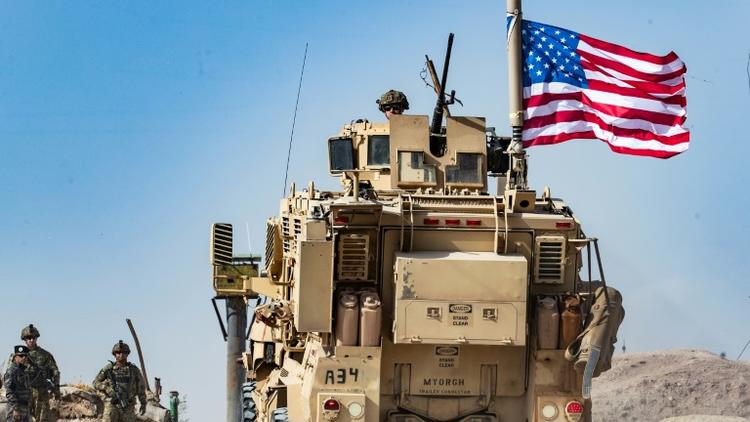 Un véhicule militaire américain lors d'une manifestation de Kurdes près de Ras al-Aïn aux abords de la frontière turque, le 6 octobre 2019 [Delil SOULEIMAN / AFP]