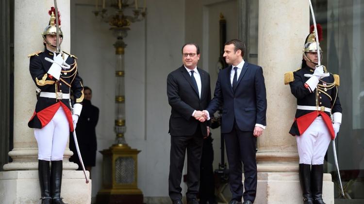 Emmanuel Macron est accueilli par son prédécesseur François Hollande, le 14 mai 2017 à l'Elysée [ERIC FEFERBERG / AFP]