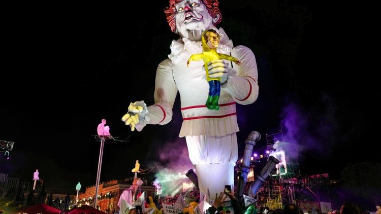Une géant figurant Donald Trump grimé en clown tueur tenant une poupée à l'effigie d'Emmanuel Macron, le 16 février 2019 au carnaval de Nice. [VALERY HACHE / AFP]