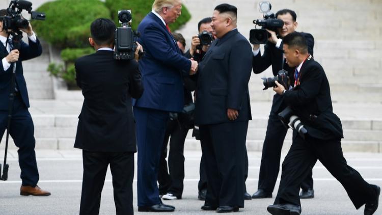 Le dirigeant nord-coréen Kim Jong Un et le président américain Donald Trump se serrent la main dans la zone démilitarisée, en Corée du Nord, à Panmunjom, le 30 juin 2019  [Brendan Smialowski / AFP]