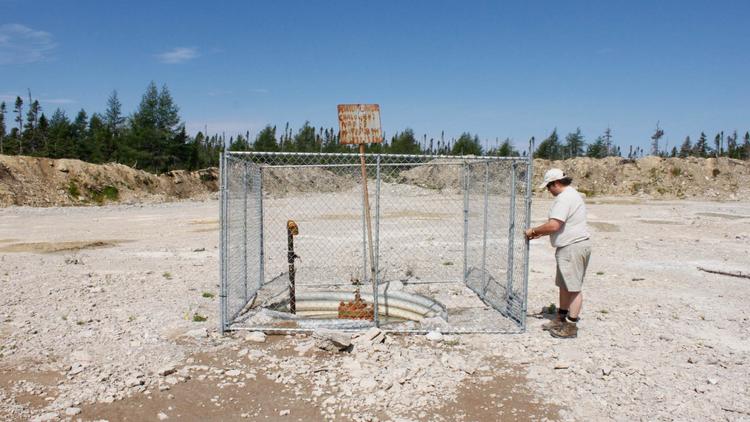 Denis Duteau, ancien maire d'Anticosti au Québec, inspecte le 13 août 2013 un puits où furent menées des explorations en 2010 [Clement Sabourin / AFP]