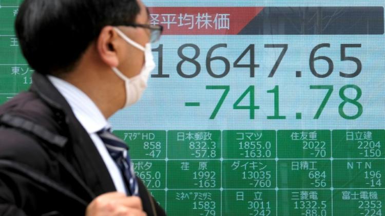 Un tableau électronique affiche le recul des cours à la Bourse de Tokyo, le 30 mars 2020 [Kazuhiro NOGI / AFP]