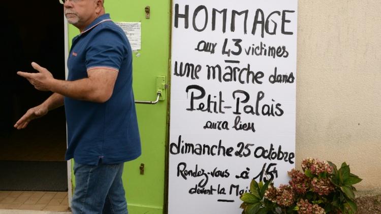 Un homme passe devant la salle des fêtes où une marche est annoncée, le 24 octobre 2015 à Petit-Palais-et-Cornemps  [JEAN-PIERRE MULLER / AFP]