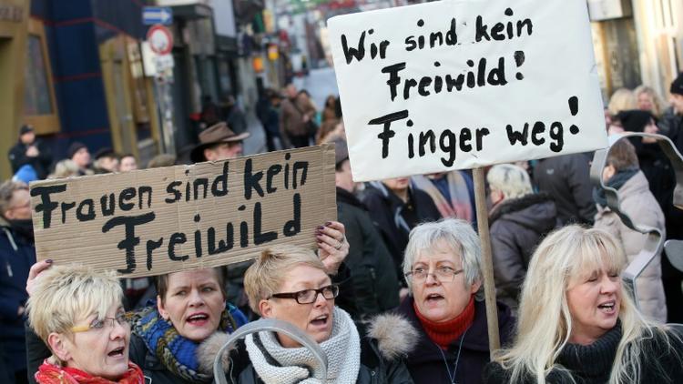 Des femmes manifestent avec des pancartes disant "Nous ne sommes pas du gibier. Bas les pattes !" à Hambourg le 10 janvier 2016 [Bodo Marks / dpa/AFP]
