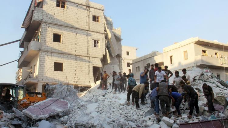 Des habitants et des casques blancs cherchent des survivants le 29 septembre 2017 sous les décombres d'un bâtiment détruit par une frappe aérienne à Harim (nord-ouest) dans la province d'Idlib  [Omar haj kadour / AFP]