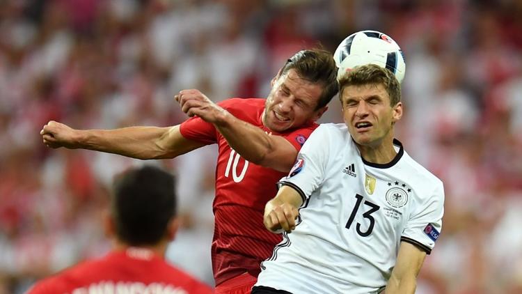 Le milieu polonais Grzegorz Krychowiak (g), dispute un ballon à l'attaquant allemand Thomas Müller, lors du match entre leurs deux équipes au premier tour de l'Euro, au Stade de France à Saint-Denis, le 16 juin 2016 [PATRIK STOLLARZ / AFP]