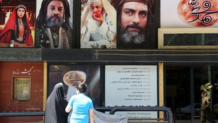 Des Iraniens devant un cinéma passant la première projection de "Mahomet", le film le plus cher de l'histoire du cinéma iranien consacré à l'enfance du prophète, le 27 août 2015 à Téhéran [ATTA KENARE / AFP]