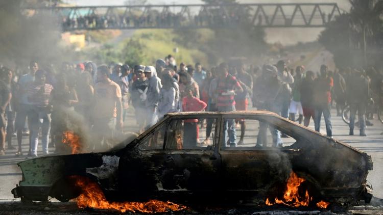 Des manifestants brûlent une voiture sur une route pour dénoncer la hausse des prix du diesel à Ribeirao das Neves au Brésil, le 25 mai 2018 [DOUGLAS MAGNO / AFP]