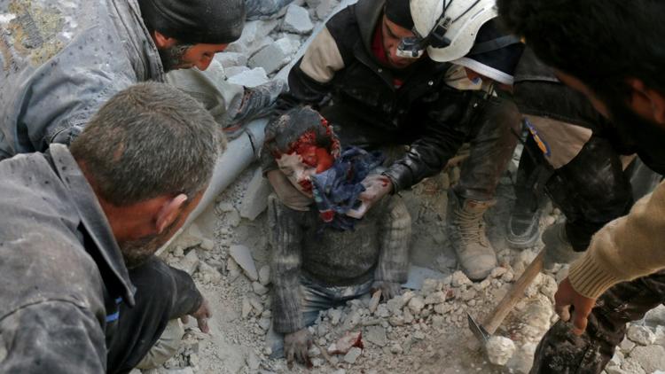 Des Casques blancs de la Défense civile syrienne sauvent un enfant des décombres d'un bâtiment détruit par un bombardement, à Bab al-Nairab, dans le nord d'Alep, le 24 novembre 2016 [AMEER ALHALBI / AFP]