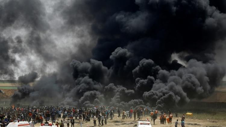 Des manifestants palestiniens brûlent pneus face à la barrière de sécurité entre Israël et la bande de Gaza, lors de nouvelles protestations à l'est de Jabaliya, le 13 avril 2018  [MOHAMMED ABED / AFP]