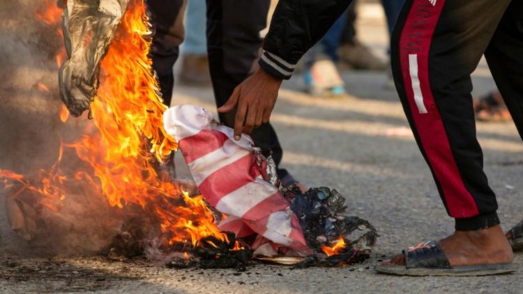 Des Irakiens brûlent le drapeau américain pour protester contre la présence des Etats-Unis, à Bassora, dans le sud de l'Irak, le 30 décembre 2019 [Hussein FALEH / AFP]