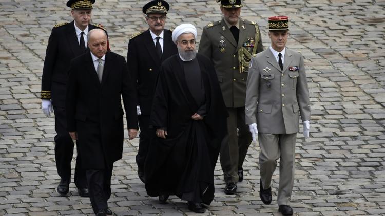 Le président iranien Hassan Rohani (c), le ministre français des Affaires étrangères Laurent Fabius, lors d'une cérémonie aux Invalides, le 28 janvier 2016 à Paris [LIONEL BONAVENTURE / AFP]