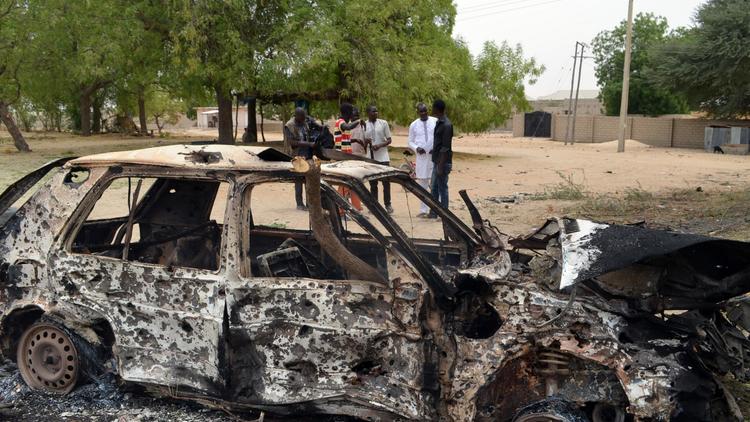 Une carcasse de voiture calcinée après une attaque attribuée au groupe islamiste Boko Haram dans la ville de Maiduguri, dans le nord du Nigeria, le 25 mars 2014 [- / AFP/Archives]