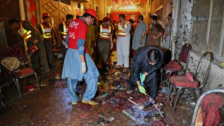 Les autorités et des volontaires sur le site de l'attaque suicide à Peshawar, le 10 juillet 2018 [ABDUL MAJEED / AFP]