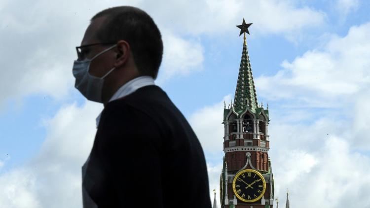 Un homme portant un masque passe devant le Kremlin, à Moscou, le 12 août 2020 [Kirill KUDRYAVTSEV / AFP/Archives]