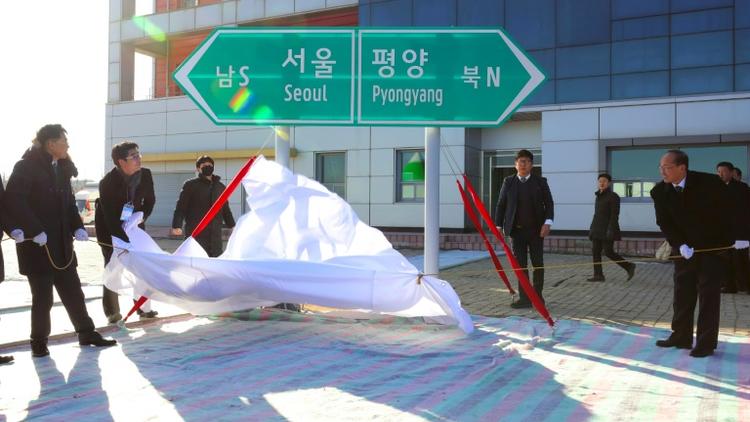 Un panneau indiquant les directions de Séoul et de Pyongyang dévoilé lors d'une cérémonie d'inauguration des travaux de connexion des réseaux ferroviaires et routiers entre les deux Corées, le 26 décembre 2018 à Kaesong, en Corée du Nord [KOREA POOL / KOREA POOL/AFP]