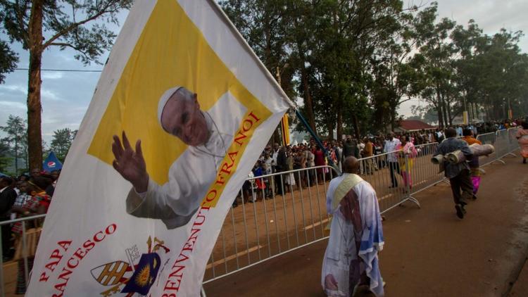 Un homme tient une bannière à l'effigie du pape François à Namugongo, en Ouganda, le 28 novembre 2015 [ISAAC KASAMANI / AFP]