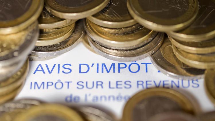 Des pièces en euros sur un avis d'imposition [Joel Saget / AFP/Archives]