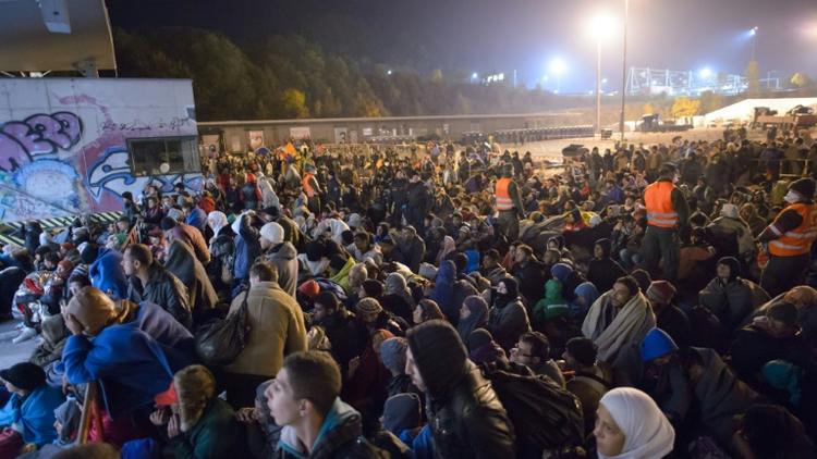 Migrants et réfugiés attendent de monter dans un bus le 23 octobre 2015 à Sentilj à la frontière entre la Slovénie et l'Autriche [Rene Gomolj / AFP]