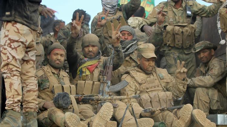 Des combattants chiites de la coalition Hachd  al-Chaabi font le signe de la victoire à l'arrivée dans un village au sud de Mossoul, le 31 octobre 2016 [AHMAD AL-RUBAYE / AFP]
