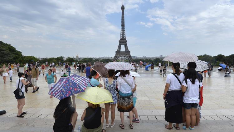 Des touristes devant la Tour Eiffel [Miguel Medina / AFP/Archives]