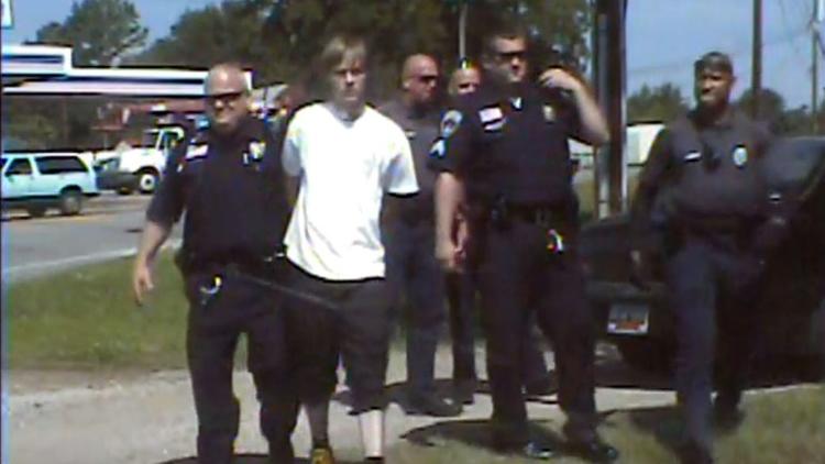 Dylann Roof, en blanc, au milieu de policiers de Shelby en Caroline du Nord après son arrestation, le 18 juin 2015 [- / Shelby Police Department/AFP/Archives]
