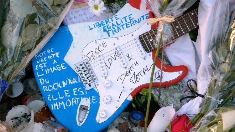 Photo prise le 26 novembre 2015 d'une guitare laissée au mémorial devant le Bataclan en souvenir des victimes de l'attaque dans cette salle de concert parisienne [BERTRAND GUAY / AFP]