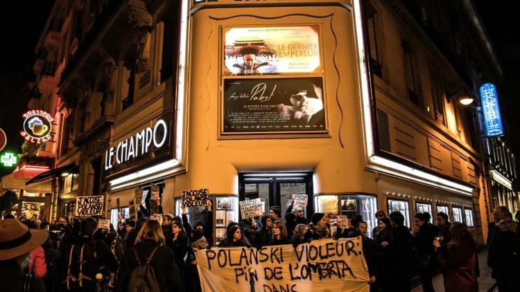 Des manifestants accusent le réalisateur Roman Polanski d'être un violeur devant un cinéma où devait être projeté son nouveau film en avant-première, le 12 novembre 2019 à Paris [Christophe ARCHAMBAULT / AFP]