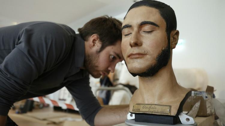 Un employé penché sur un buste au musée de l'Homme à Paris, le 13 octobre 2015 [Patrick Kovarik / AFP]