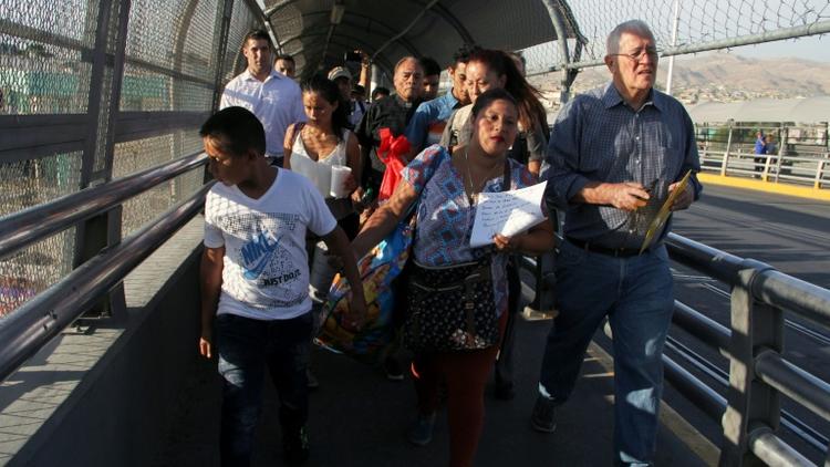 Un groupe de migrants du Honduras et du Guatemala, accompagnés d'un volontaire d'une association, franchissent la frontière depuis le Mexique pour aller réclamer l'asile politique aux Etats-Unis, le 15 juin 2018  [Herika Martinez / AFP]