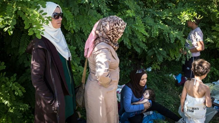 Des femmes attendent à Bapska en Croatie à la frontière avec la Serbie, le 23 septembre de monter dans des autobus pour les conduire dans un centre de transit [FEDERICO SCOPPA / AFP]