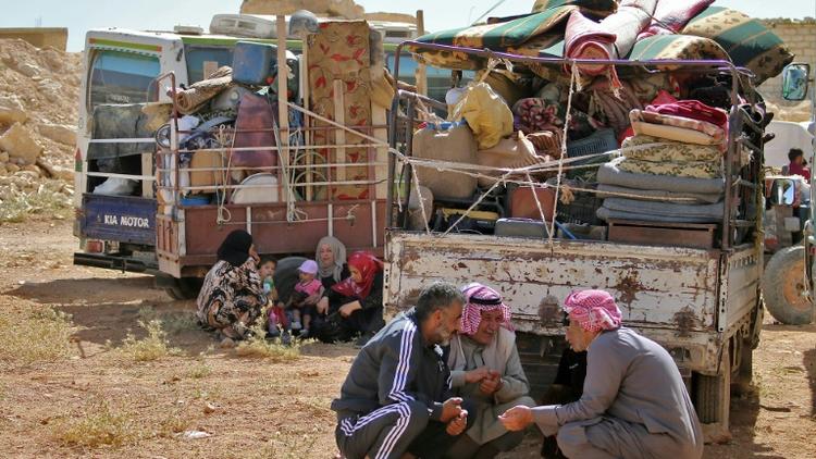 Des réfugiés syriens attendent le départ du convoi qui les ramènera chez eux, dans la localité d'Arsal, dans l'est du Liban, le 28 juin 2018 [STRINGER / AFP]