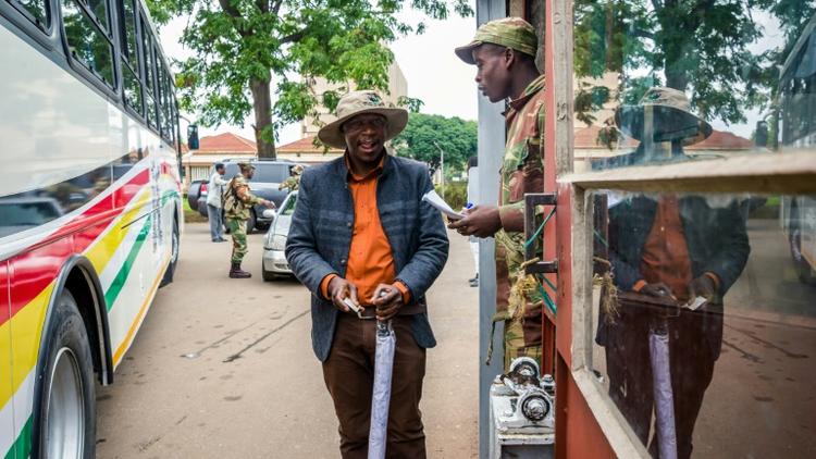 Un soldat contrôle des délégués à leur arrivée à une réunion cruciale du parti au pouvoir dimanche à Harare alors que le président Mugabe est lâché par ses principaux soutiens [Jekesai NJIKIZANA / AFP]