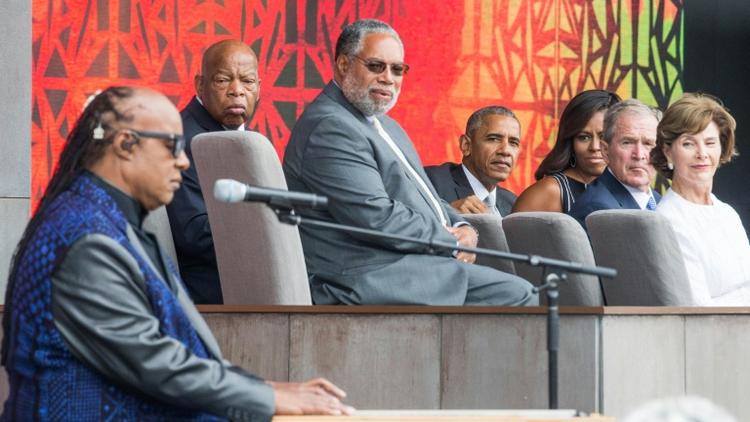 Stevie Wonder chante en présence de Barack Obama (au c.) et de son prédécesseur Georges W. Bush (2e à d.) lors de l'inauguration du Musée dédié à la culture afro-américaine, le 24 septembre 2016 à Washington [ZACH GIBSON / AFP]