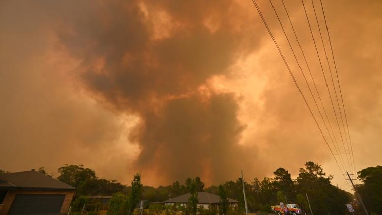 Des fumées d'incendie près de maisons à Bargo, en banlieue de Sydney (Australie), le 21 décembre 2019 [PETER PARKS / AFP/Archives]