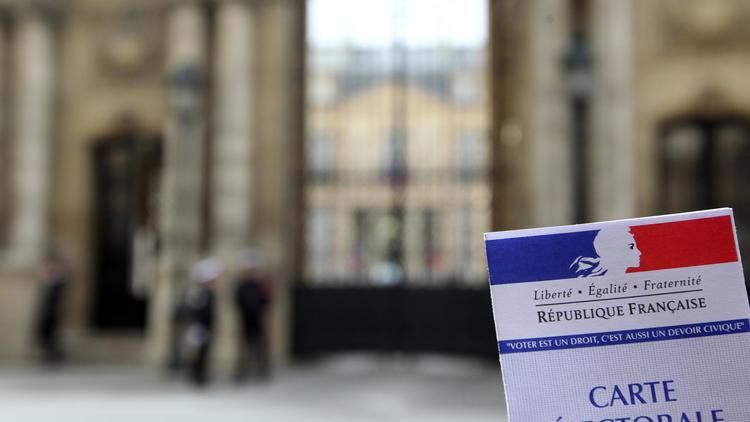 Une carte électorale avec en arrière-fond le palais de l'Elysée qui abrite la présidence de la République, à Paris [Kenzo Tribouillard / AFP/Archives]