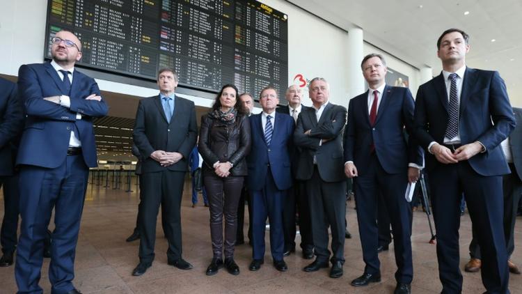 Le Premier ministre Charles Michel (g), et le ministre de l'Intérieur belge, Jan Jambon (2e g), à l'aéroport de Zaventem, près de Bruxelles, lors de la cérémonie de réouverture du hall des départs, fermé depuis les attentats du 22 mars dernier [NICOLAS MAETERLINCK / Belga/AFP]