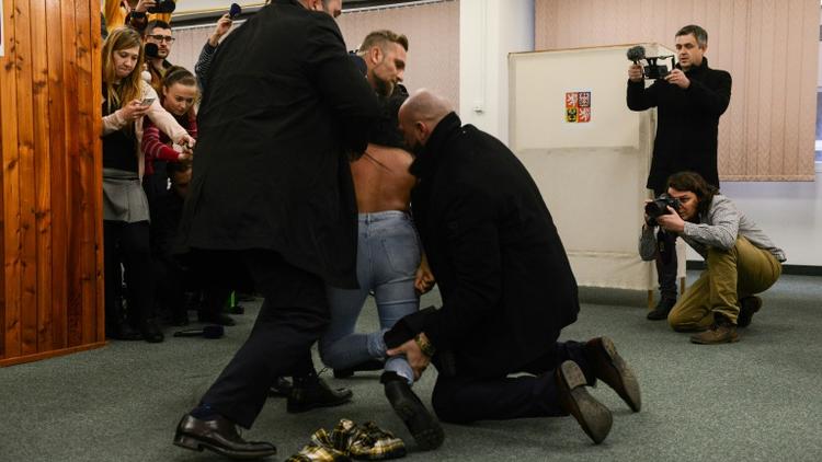 Les membres de la sécurité du président tchèque Milos Zeman interpellent une Femen à Prague, le 12 janvier 2018 [Michal Cizek / AFP]