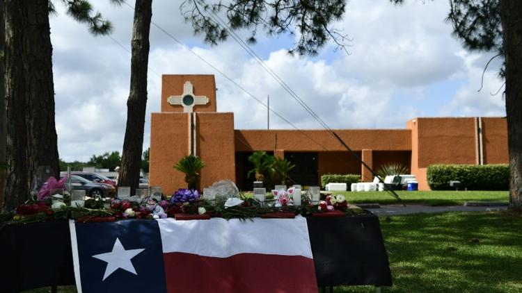Des fleurs et un drapeau texan en hommage aux victimes, devant le lycée de San Fe le 19 mai 2018 [Brendan Smialowski / AFP]