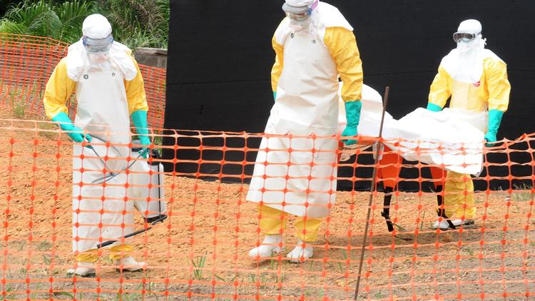 Des membres de Médecins sans frontière transportant le corps d'un défunt de la fièvre Ebola à Guékédou, en Guinée, le 1er avril 2014 [Seyllou / AFP/Archives]
