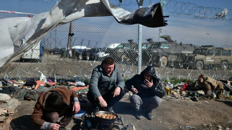 Des migrants font cuire des pommes de terre dans un camp de réfugiés à la frontière entre la Grèce et la Macédoine à Idomeni, le 19 mars 2016 [LOUISA GOULIAMAKI / AFP]