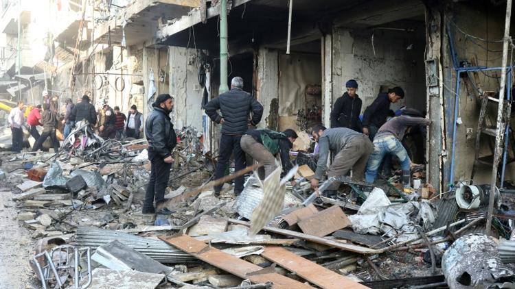 Des habitants au milieu des décombres d'immeubles après des frappes aériennes, le 4 décembre 2016 à Maaret al-Noomane, en Syrie [Mohamed al-Bakour / AFP/Archives]