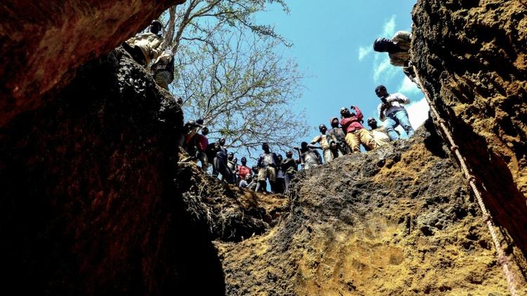 Des mineurs illégaux au bord d'un gouffre où ils espèrent trouver des pierres précieuses, près du village de Nthoro, le 3 août 2018 au Mozambique  [EMIDIO JOSINE / AFP]
