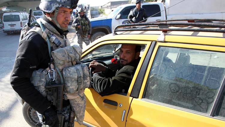 Un policier irakien contrôle une voiture à Bagdad, le 16 décembre 2013 [Ali al-Saadi / AFP/Archives]