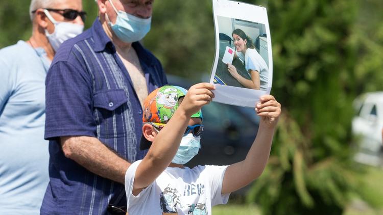 Le fils de Delphine Jubillar, disparue en décembre 2020, et Cédric Jubillar, brandit une photo de sa mère lors d'un rassemblement avec ses collègues et ses proches à Albi, dans le sud de la France, le 12 juin 2021. 