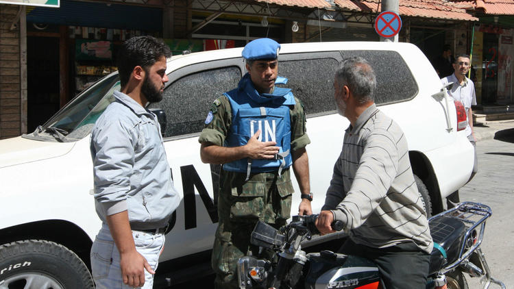 Un observateur de l'ONU parle à un habitant de la ville de Madaya, en Syrie, le 6 mai 2012. 
