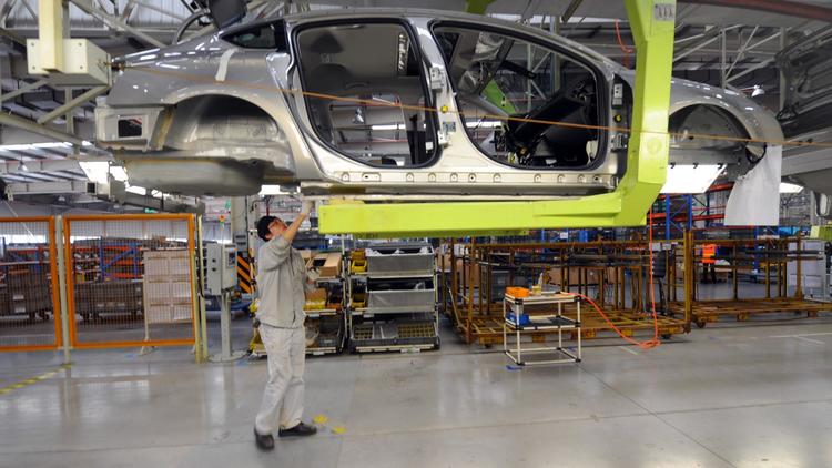 Une personne travaille dans une usine d'assemblage de PSA Peugeot Citroën à Wuhan dans le centre de la Chine, le 11 avril 2013
